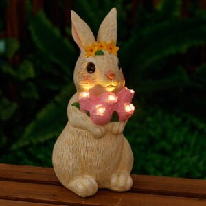 Garden white rabbit holding a flower